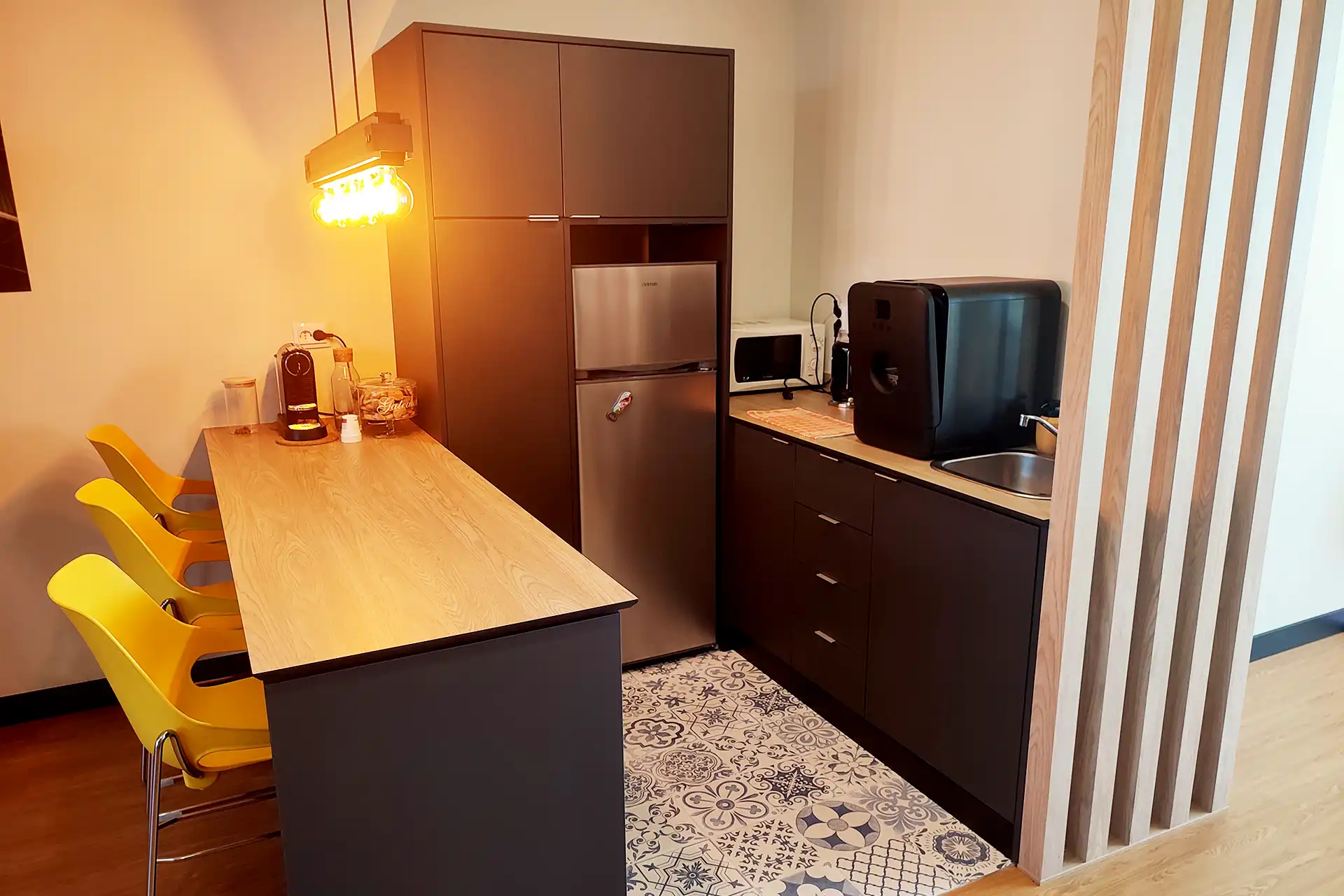 coworking kitchenette with coffee station and yellow bar stools in Lavra