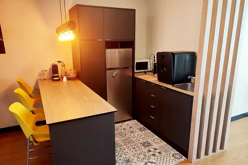 coworking kitchenette with coffee station and yellow bar stools in Lavra
